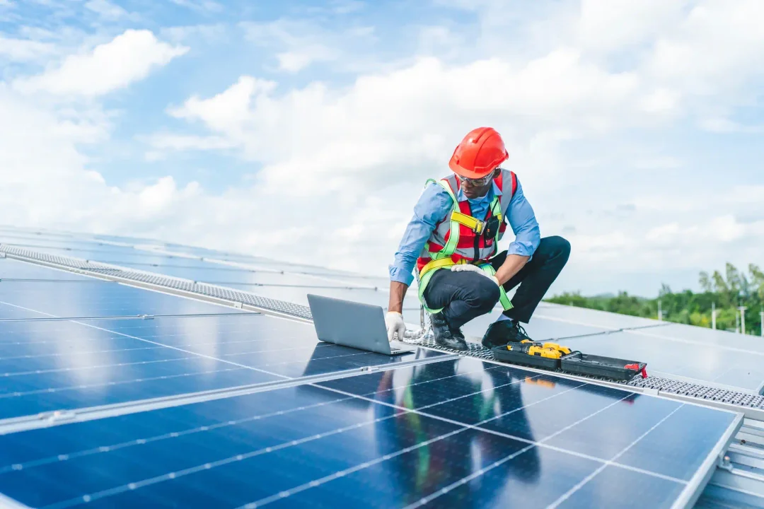 Man working on solar energy system in a rooftop at morning